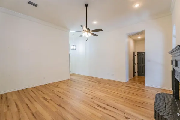 a view of a room with a ceiling fan and a wooden floor