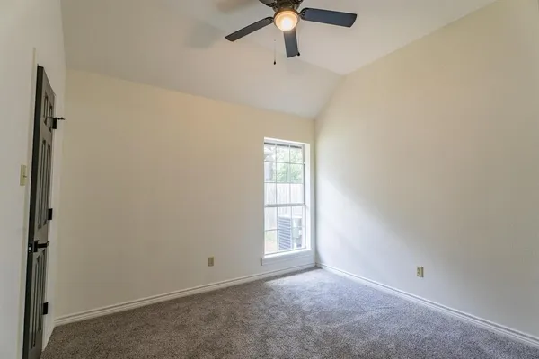 an empty room with a window and a fan