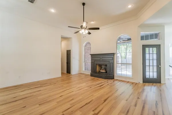 a view of an empty room with a fireplace and a window