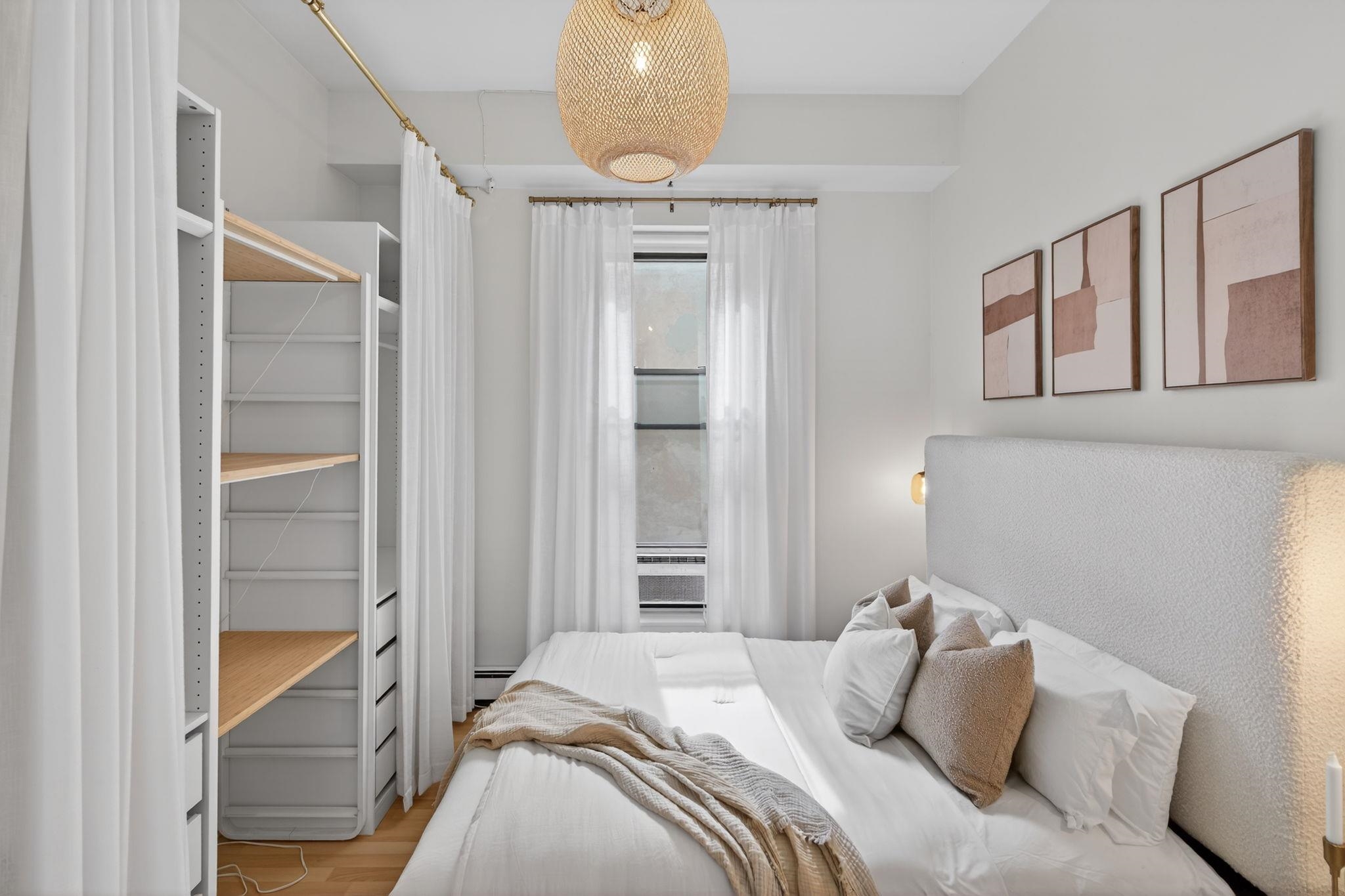 723 Washington Street, Unit 5 Hoboken, NJ 07030 - Photo 15 of 25 a bedroom with a bed and a chandelier
