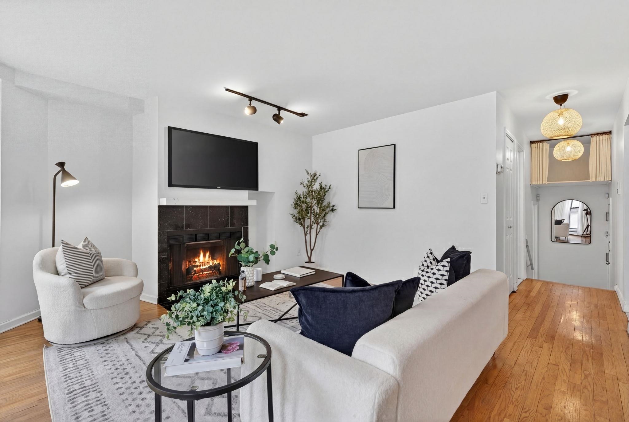 723 Washington Street, Unit 5 Hoboken, NJ 07030 - Photo 3 of 25 a living room with furniture a fireplace and a flat screen tv