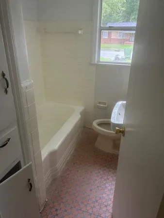 a white toilet sitting next to a bath tub