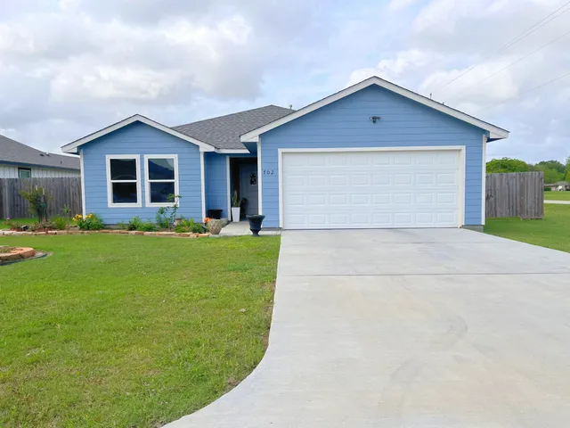 a front view of house with yard and green space