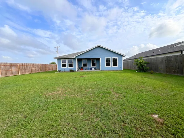 a view of a house with a yard and sitting area