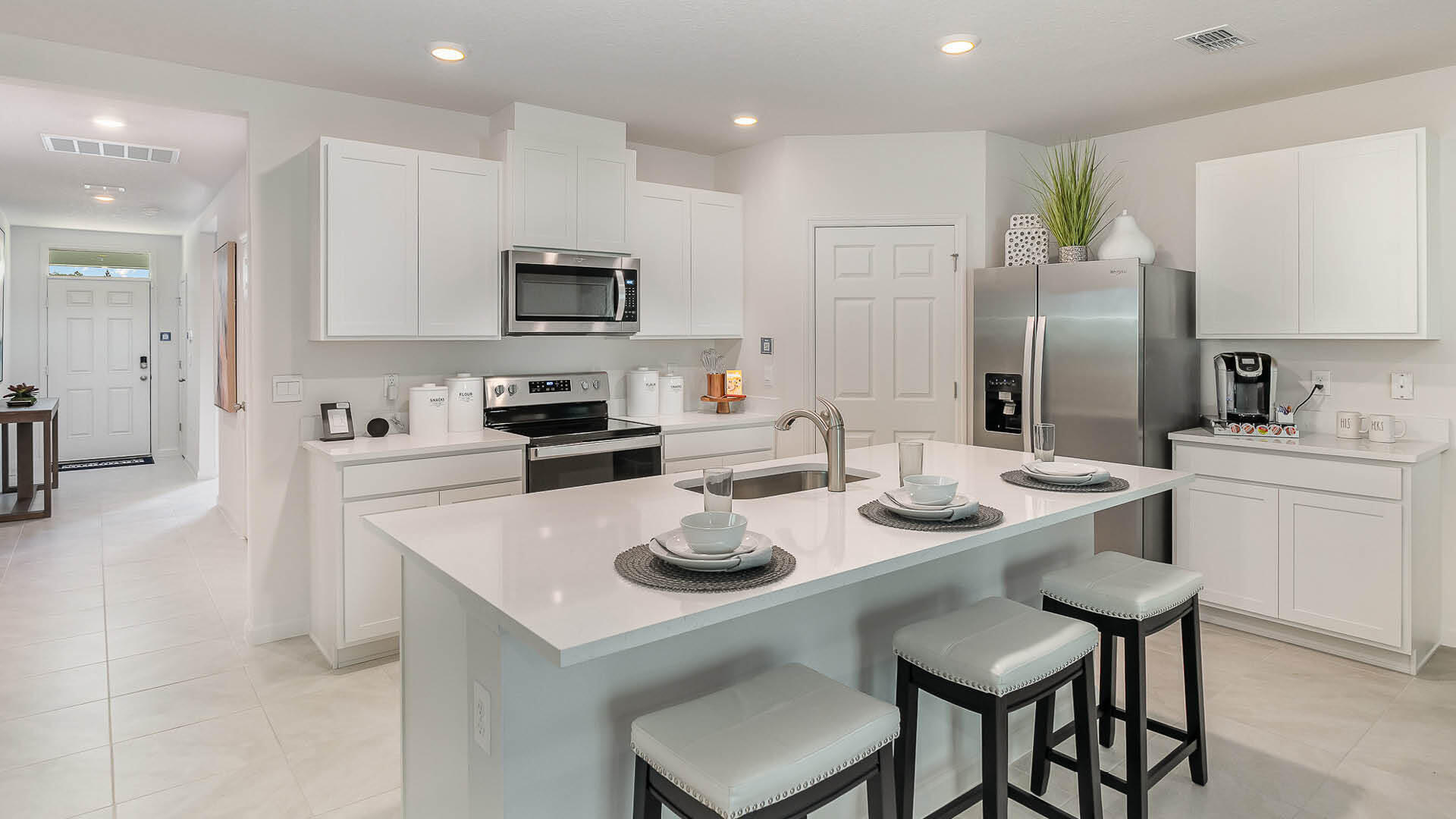716 Northeast 15th Avenue Okeechobee, FL 34972 - Photo 8 of 26 a kitchen with stainless steel appliances granite countertop a sink a stove a refrigerator and white cabinets with wooden floor