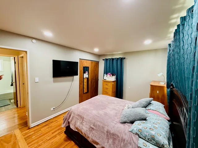 a bedroom with a bed and a flat screen tv