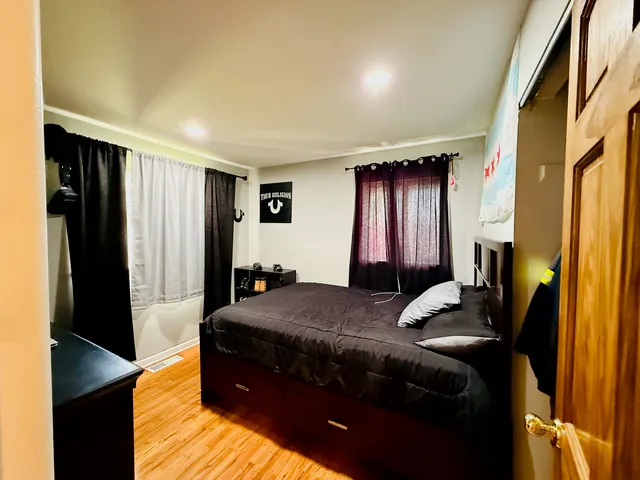 a bedroom with a bed and wooden floor