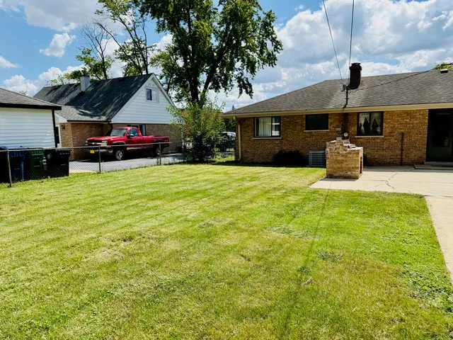 a view of a house with backyard and sitting area