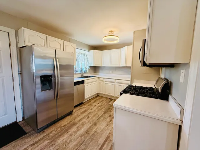 a kitchen with a refrigerator sink and cabinets