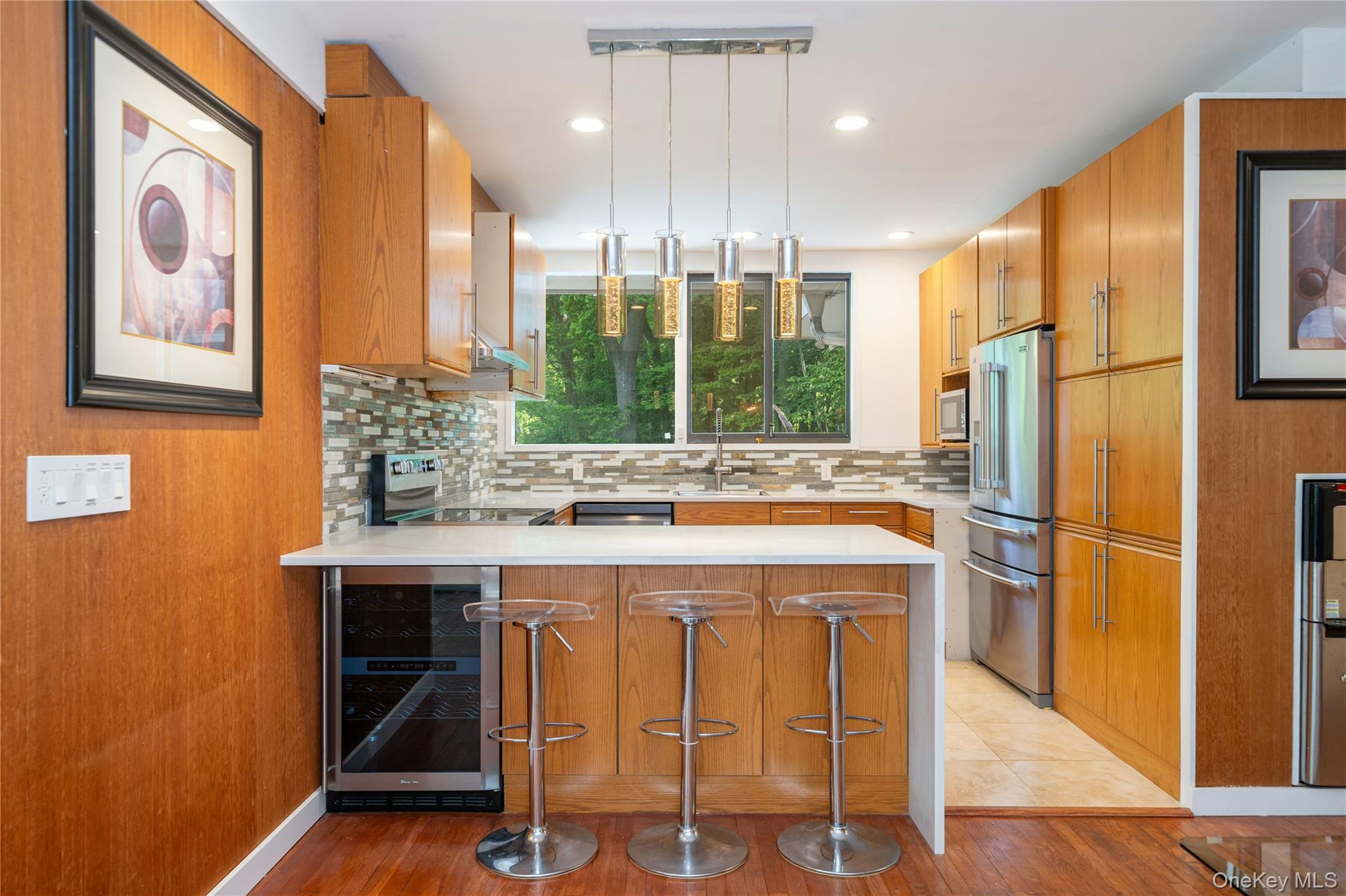4 Half Mile Road Armonk, NY 10504 - Photo 8 of 28 Updated mid century modern kitchen with warm wood cabinetry, quartz countertops, stainless steel appliances, and a spacious breakfast bar.