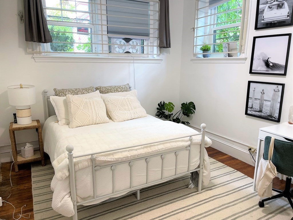 33 Winslow Road, Unit B Brookline, MA 02446 - Photo 5 of 14 a bedroom with a bed wooden floor and window
