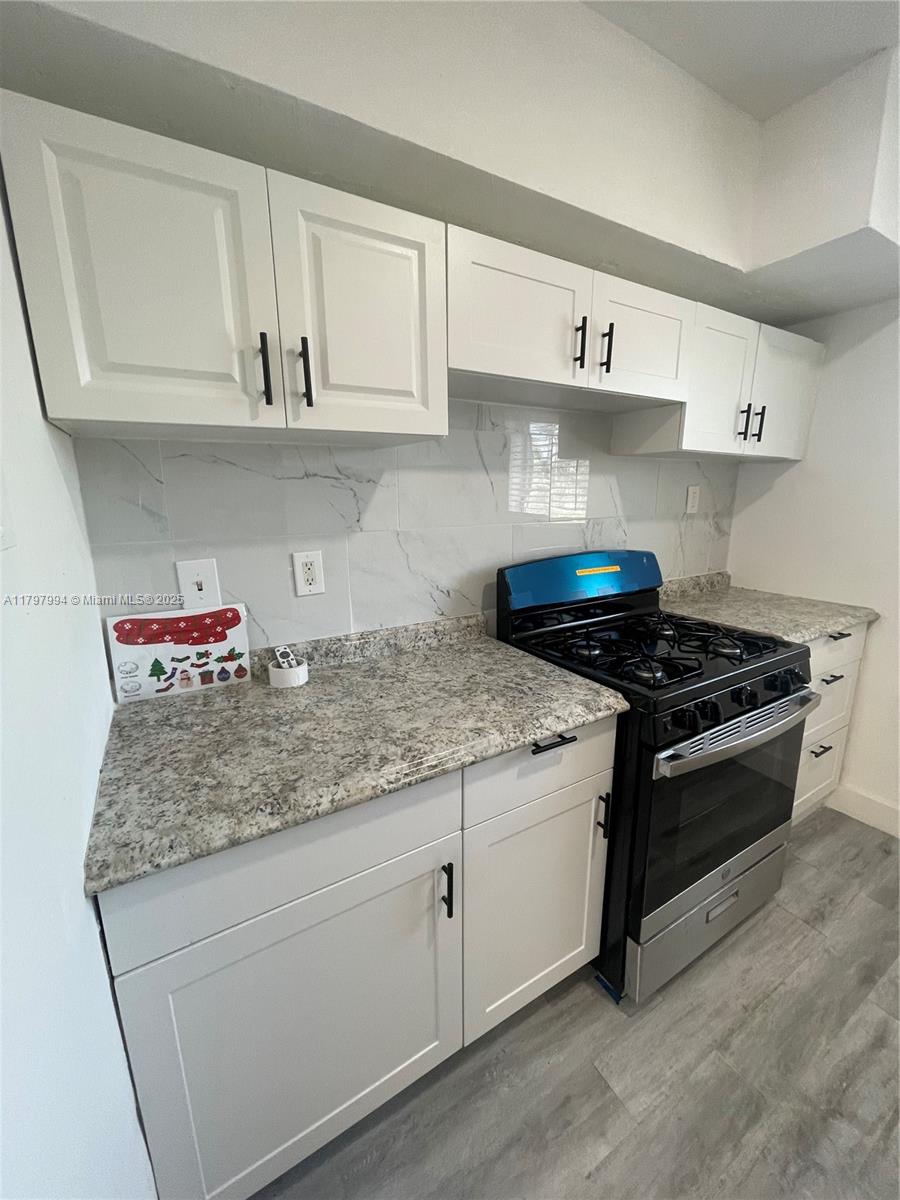 Surfside Surfside, FL 33154 - Photo 2 of 8 a kitchen with stainless steel appliances granite countertop a sink dishwasher stove and white cabinets