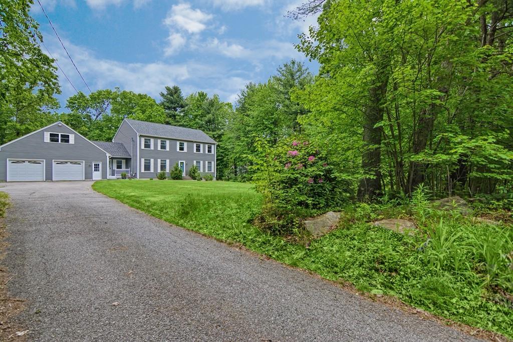 173 Webster Street Douglas, MA 01516 - Photo 2 of 42 a view of a house with a small yard and large trees