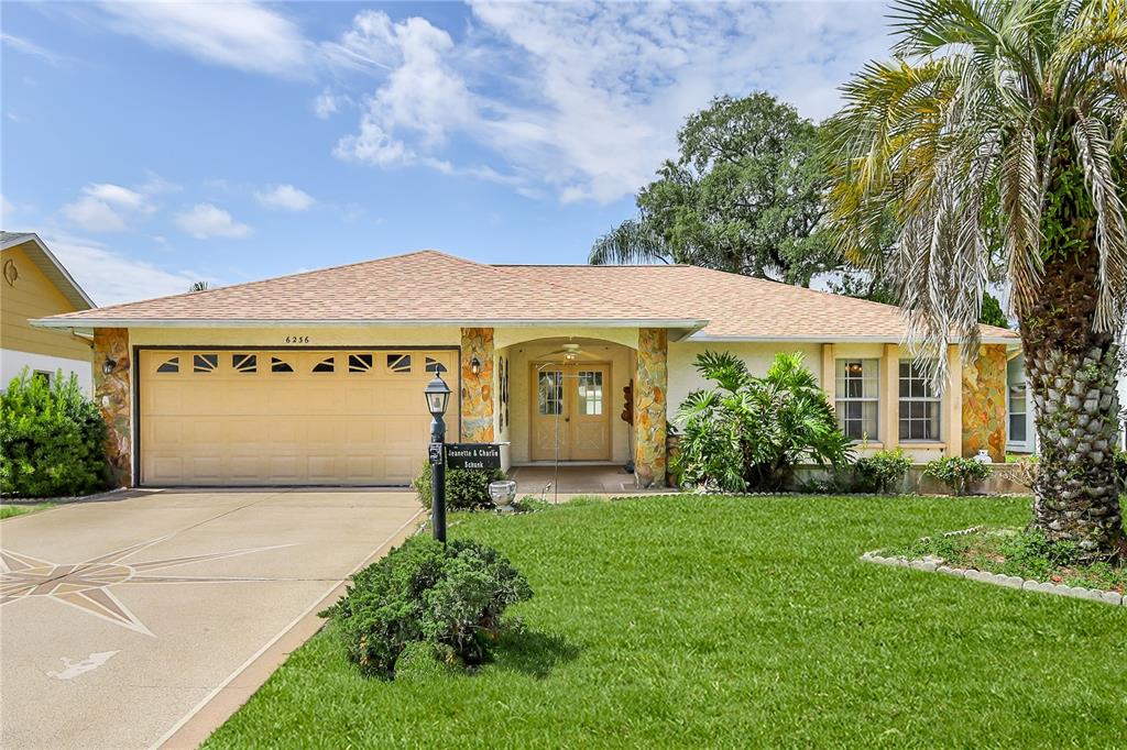 6236 Ocean Pines Lane Spring Hill, FL 34606 - Photo 1 of 1 a front view of a house with a yard and garage
