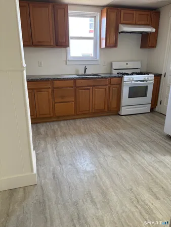 a kitchen with granite countertop a sink and a stove top oven
