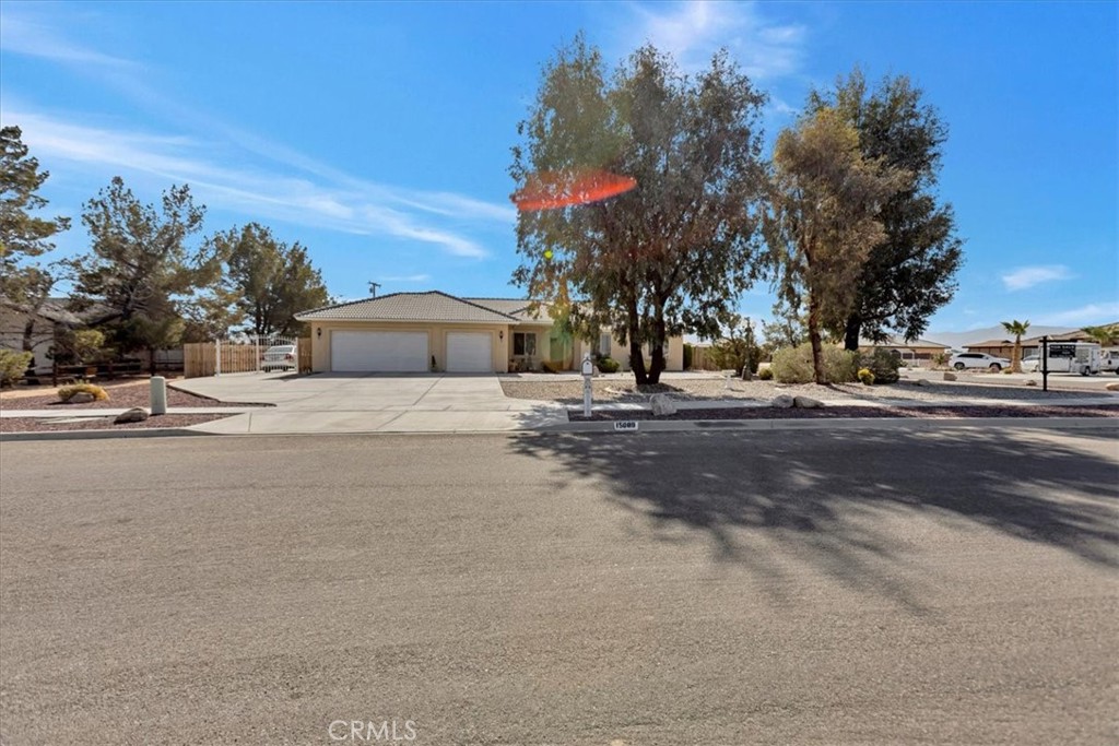15089 Osage Road Apple Valley, CA 92307 - Photo 1 of 1 a front view of a house with a yard and trees