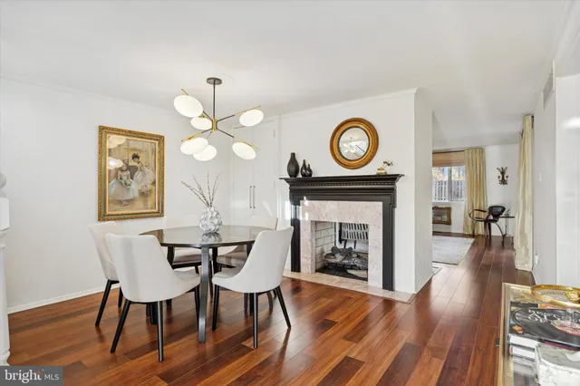 a view of a dining room with furniture a fireplace and wooden floor