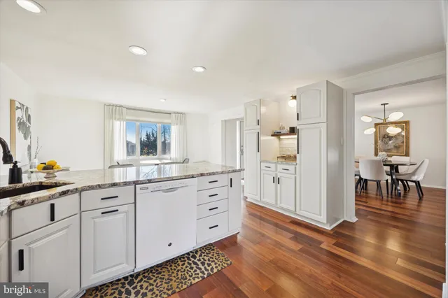 a kitchen with white cabinets and sink