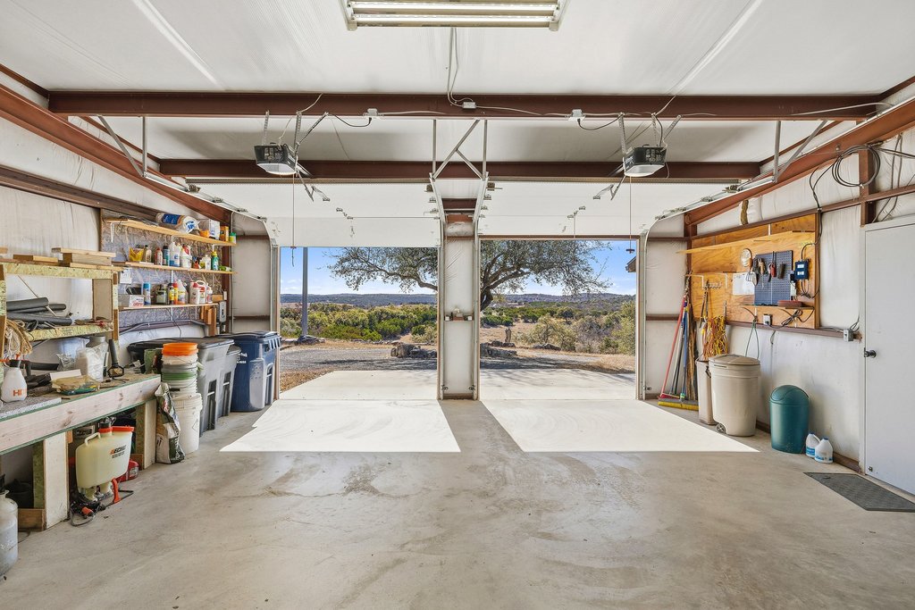 1292 Upper Turtle Creek Road Kerrville, TX 78028 - Photo 31 of 40 Garage with a garage door opener and a workshop area