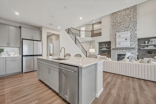 a kitchen with stainless steel appliances granite countertop a sink and a refrigerator