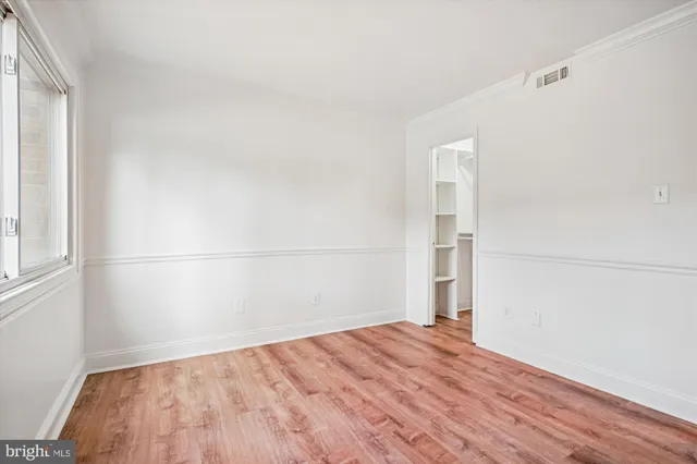 a view of empty room with wooden floor