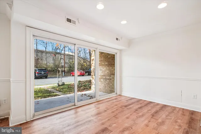 a view of empty room with wooden floor and sliding door