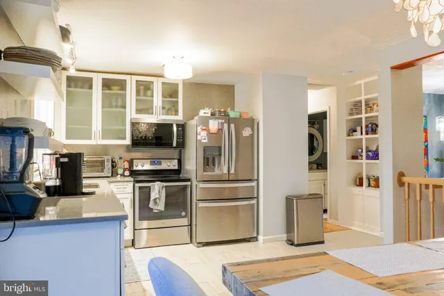 a kitchen with stainless steel appliances granite countertop a refrigerator a stove and a sink with wooden floor