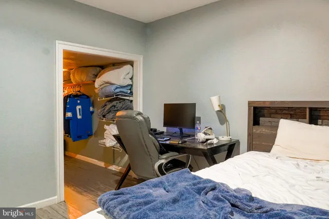 a bedroom with a bed and a computer on a table