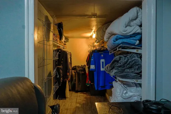 a view of walk in closet with clothes and shoes