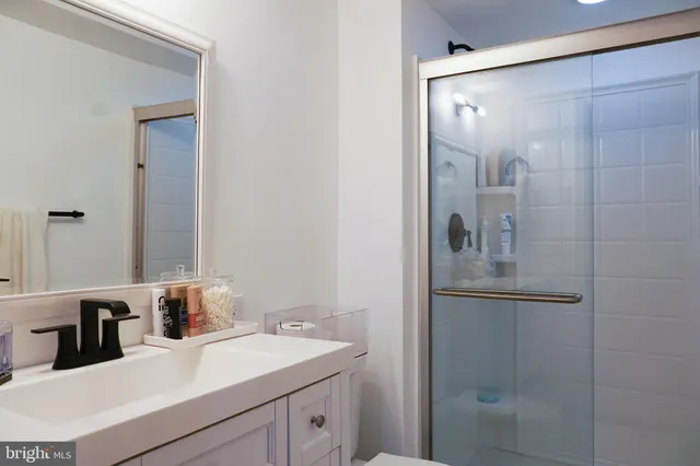 a bathroom with a shower sink and mirror