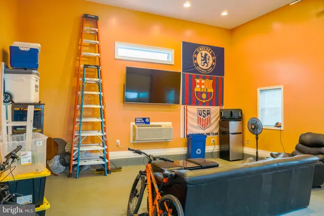 a living room with furniture a flat screen tv and a window