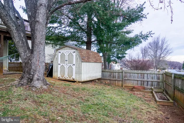 a view of a yard with large tree and wooden fence