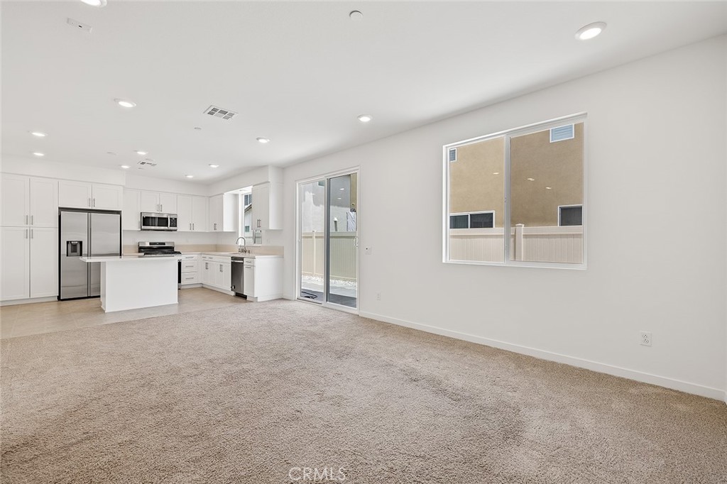 1942 North Florish Drive Compton, CA 90222 - Photo 11 of 47 a view of a kitchen with stainless steel appliances refrigerator stove a microwave and white cabinets