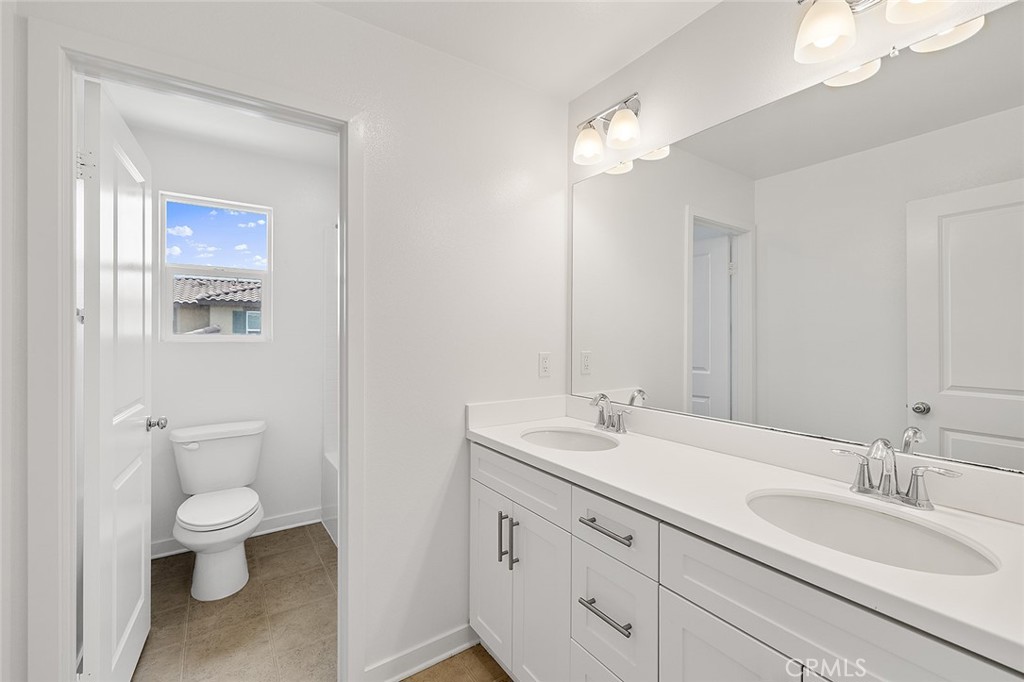 1942 North Florish Drive Compton, CA 90222 - Photo 32 of 47 a bathroom with a toilet a sink and mirror