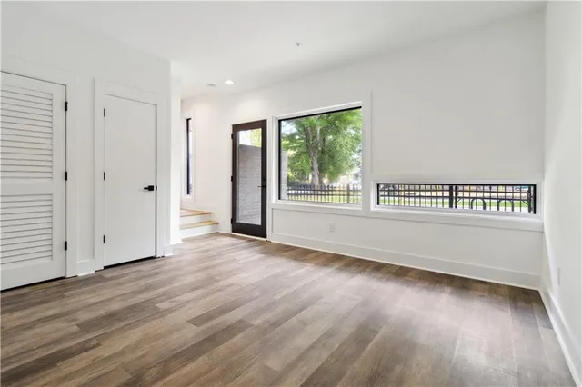 an empty room with wooden floor and window