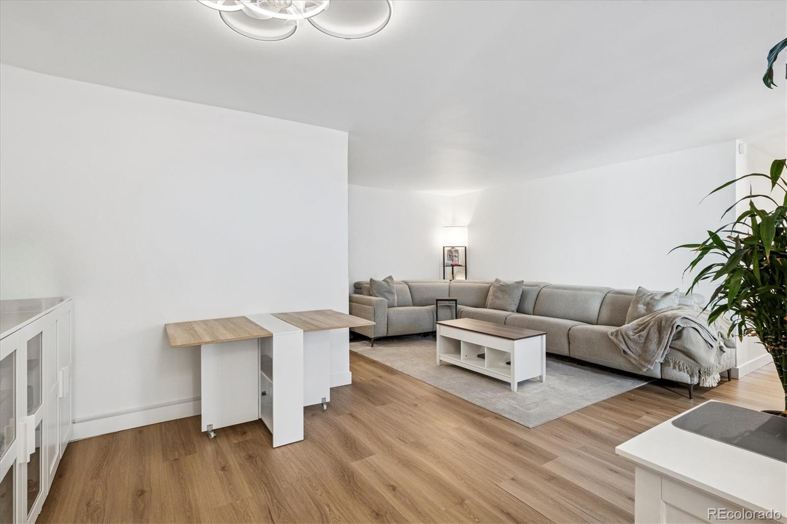 2 Adams Street, Unit 510 Denver, CO 80206 - Photo 14 of 37 a living room with furniture and a wooden floor
