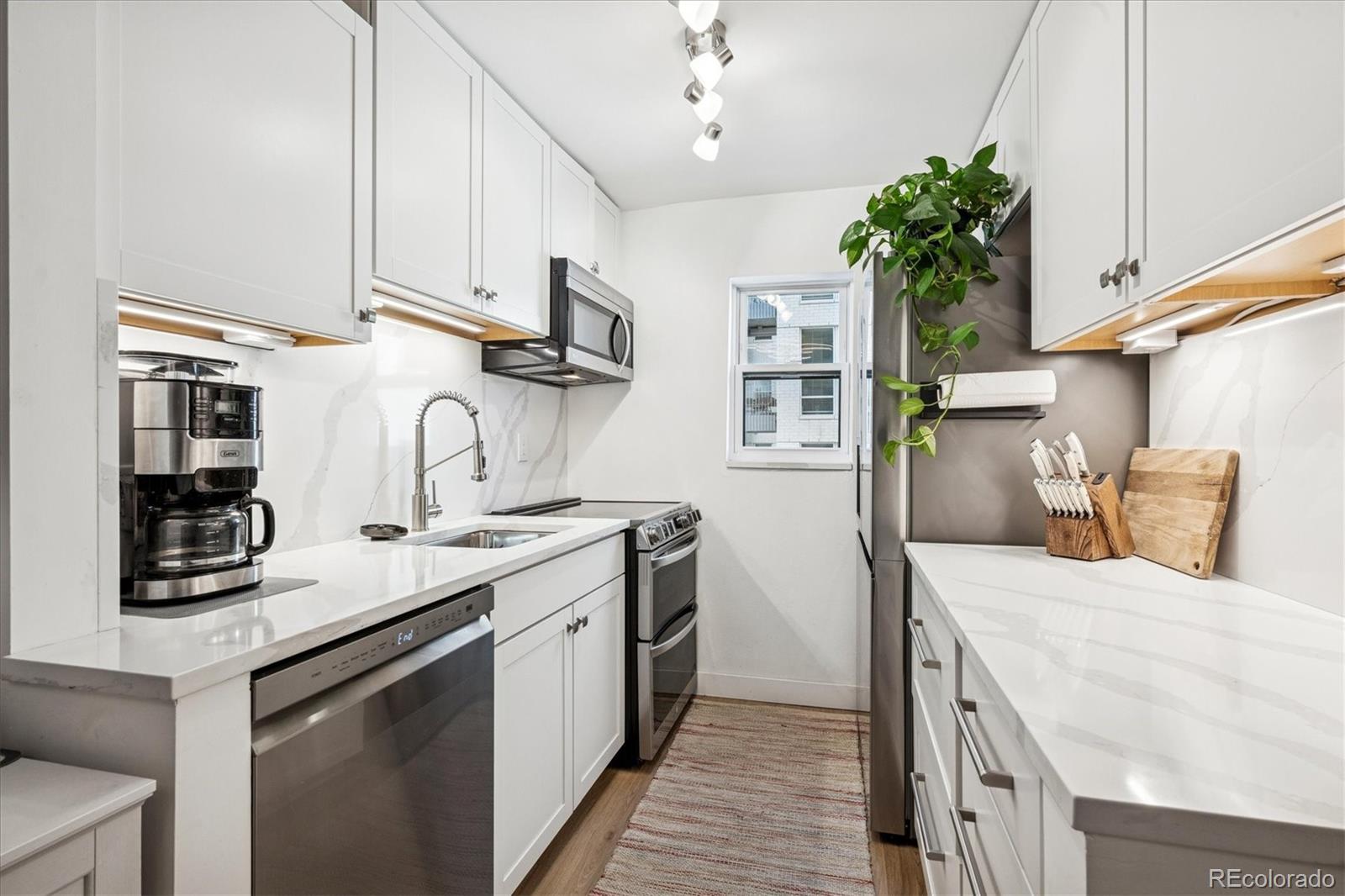 2 Adams Street, Unit 510 Denver, CO 80206 - Photo 2 of 37 a kitchen with stainless steel appliances granite countertop a sink a stove and a refrigerator