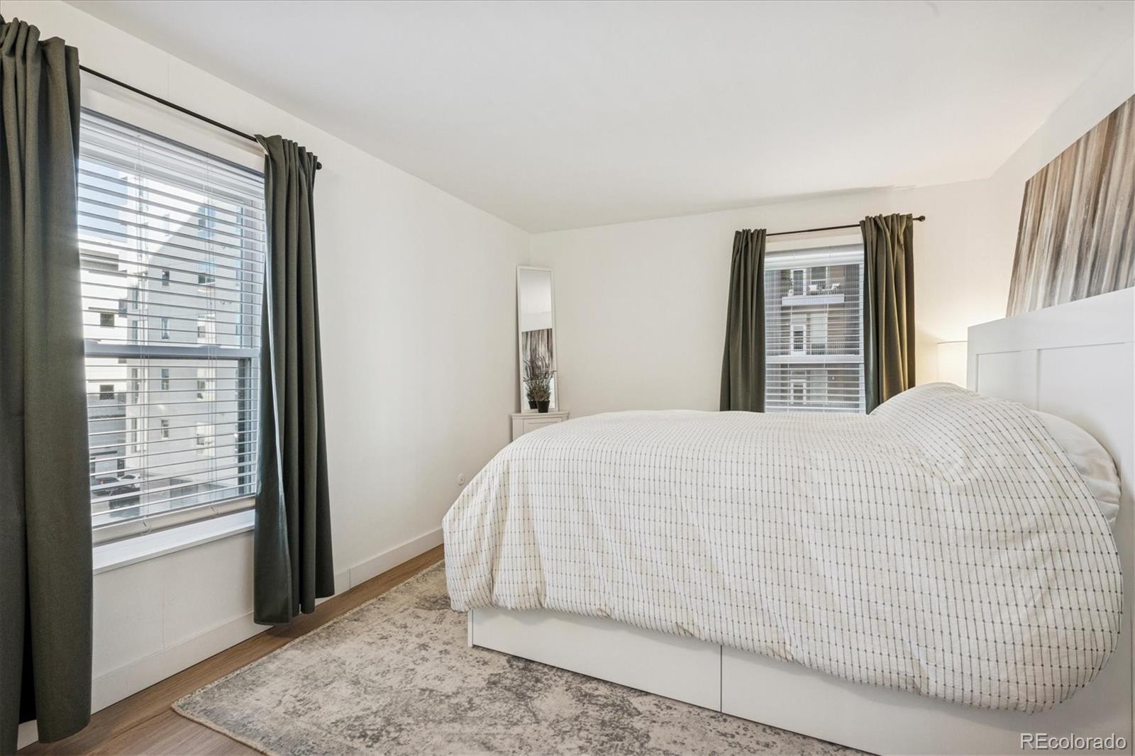 2 Adams Street, Unit 510 Denver, CO 80206 - Photo 24 of 37 a large bed sitting in a bedroom next to a window