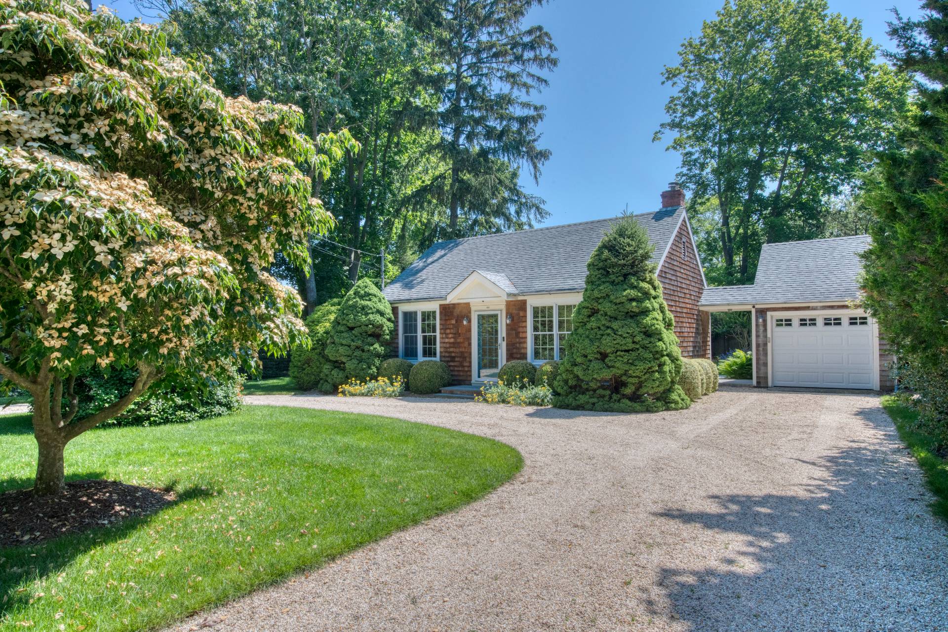 a front view of a house with a yard and trees