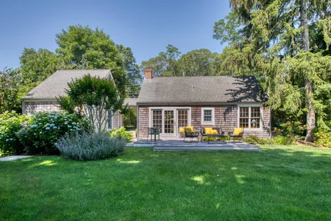 a view of house with backyard and outdoor seating