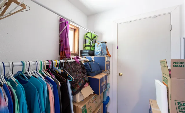 a view of walk in closet with clothes and shoes