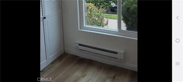 a view of a small space with wooden floor and a window