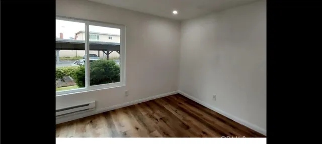 a view of a small space with wooden floor and a window