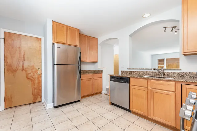a kitchen with stainless steel appliances granite countertop a refrigerator and a sink