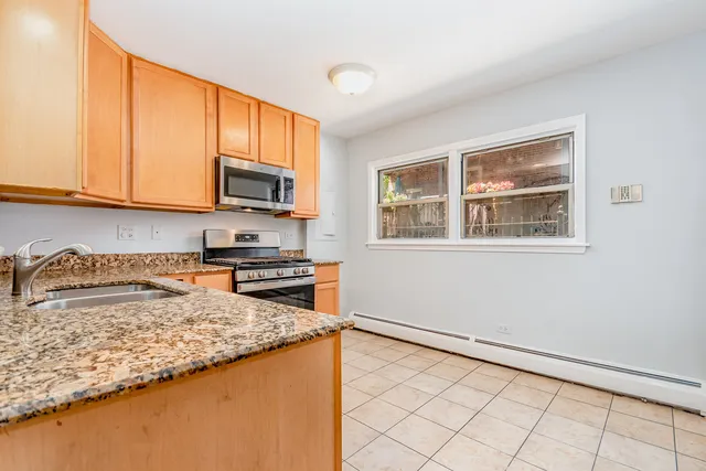 a kitchen with granite countertop a stove a sink and a microwave