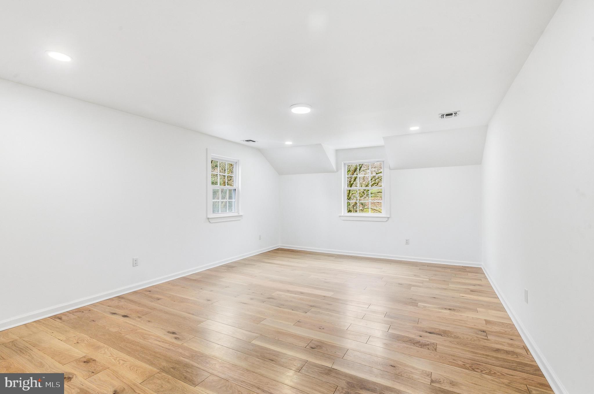 201 Church Road Devon, PA 19333 - Photo 14 of 21 an empty room with wooden floor and windows