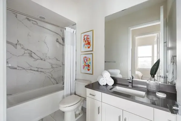 a bathroom with a double vanity sink toilet and shower