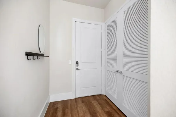 a view of a hallway with wooden floor and staircase
