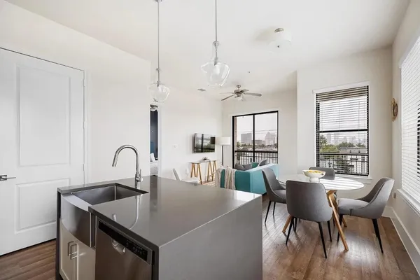 a kitchen with stainless steel appliances granite countertop a sink dishwasher a refrigerator and a stove with wooden floor