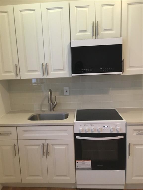 9307 3rd Avenue Brooklyn, NY 11209 - Photo 16 of 23 a kitchen with a stove and white cabinets